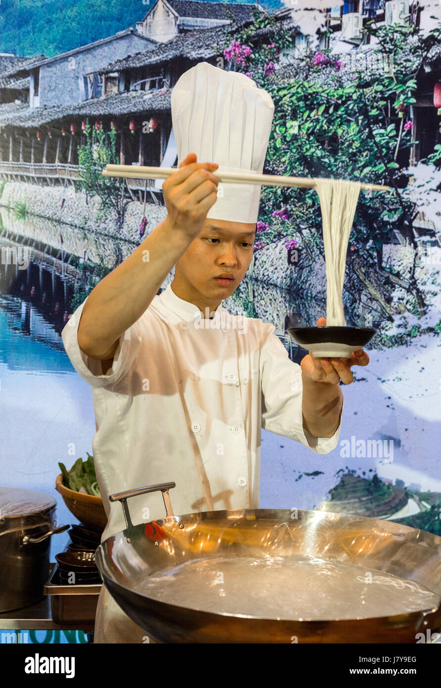Wenzhou, Zhejiang, Chine. Le chef de l'hôtel démontrant la cuisiner et servir des nouilles. Banque D'Images
