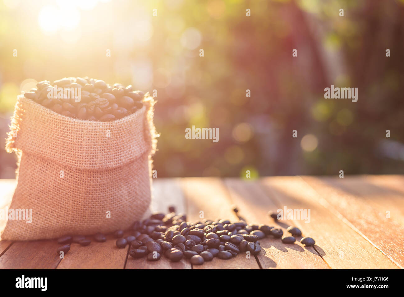 Close up de café torréfié dans petit sac sur la table en bois. Tournage en extérieur avec la lumière du soleil et l'arrière-plan flou Banque D'Images