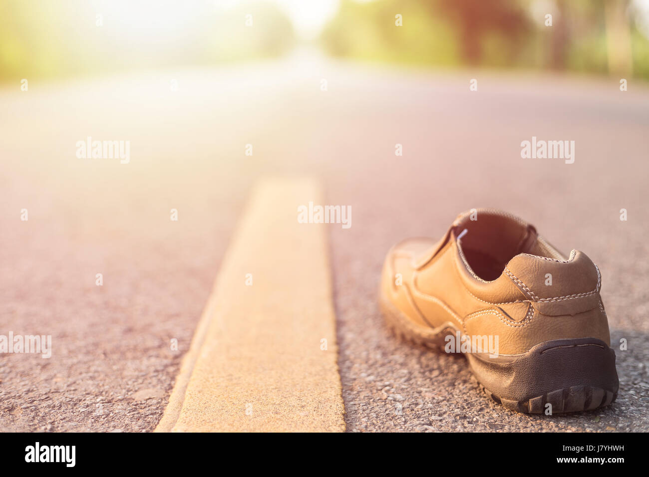 Close up nouveau côté droit hommes chaussures de mode sur route asphaltée, à côté d'une bande jaune Banque D'Images