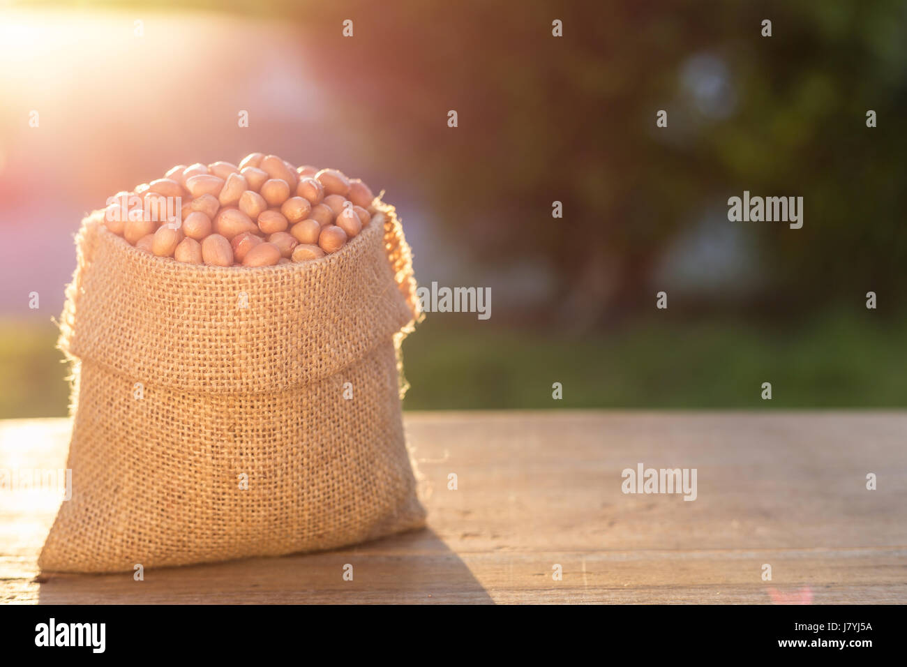 Close up peanut en petit sac sur la table en bois. Tournage en extérieur avec la lumière du soleil et l'arrière-plan flou Banque D'Images