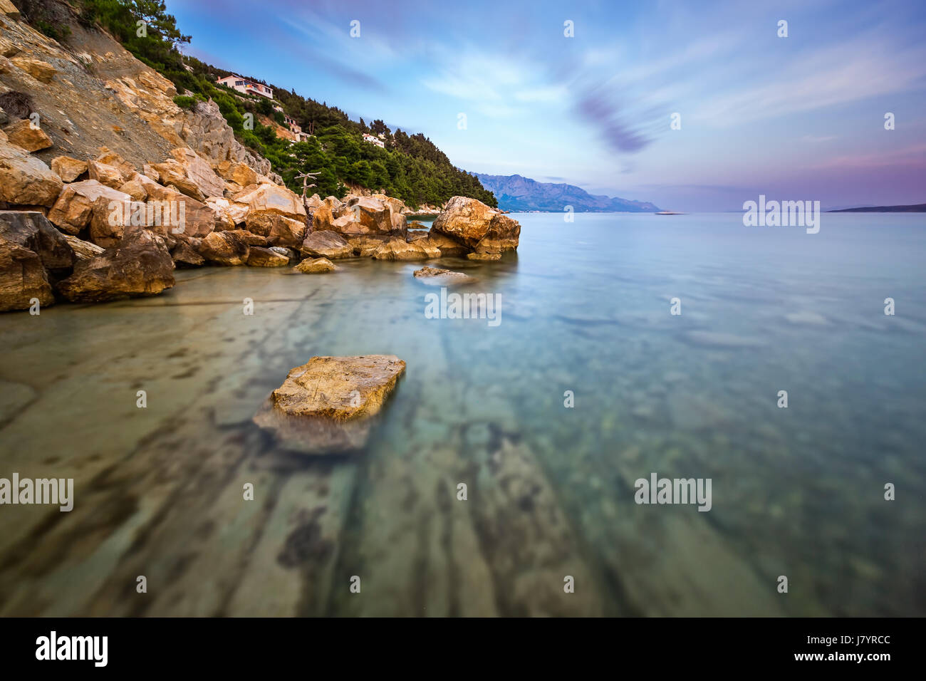 Plage de rochers et mer transparente près de omis dans la soirée, la Dalmatie, Croatie Banque D'Images