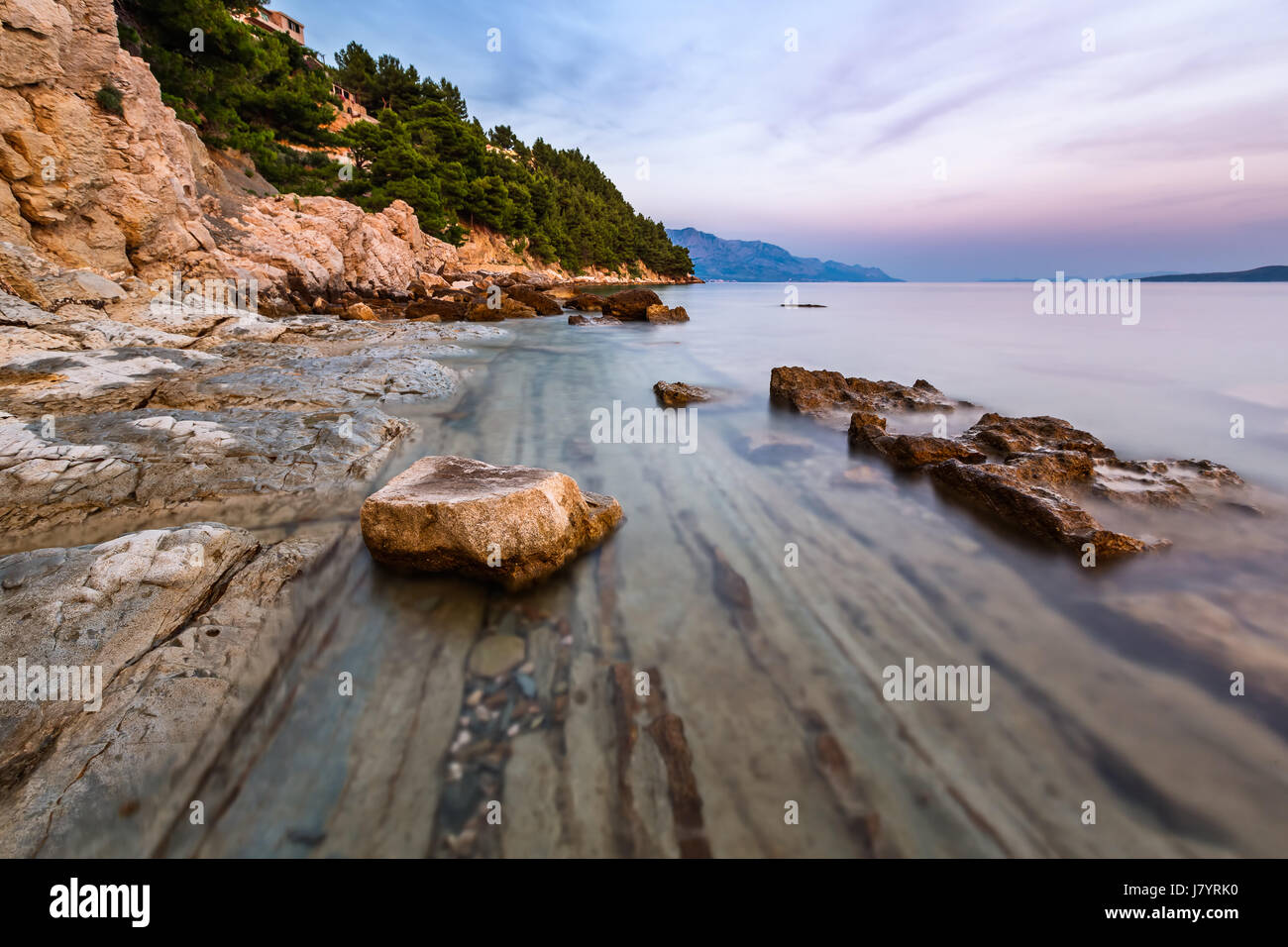 Plage de rochers et mer transparente près de omis dans la soirée, la Dalmatie, Croatie Banque D'Images