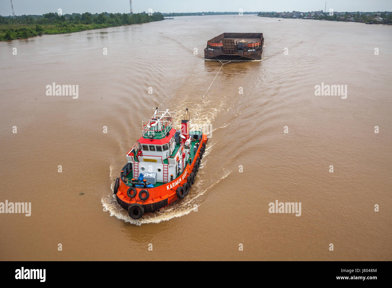 Un remorqueur tire une barge vide sur le fleuve Batangari à Muara Sabak, Tanjung Jabung est, Jambi, Indonésie. Banque D'Images