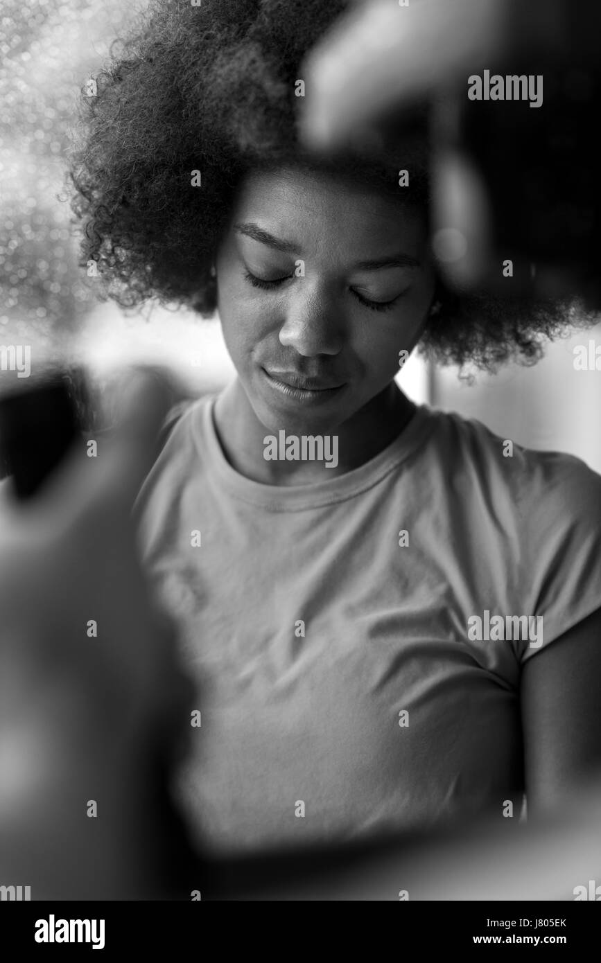 Belle african american woman using tablet computer de la maison tandis que la pluie et le mauvais temps est de plein air Banque D'Images