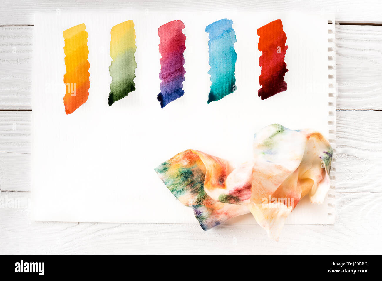 Vue de dessus de traits de peinture colorée sur papier froissé et serviette dans la peinture Banque D'Images Vue de dessus de traits de peinture colorée sur papier froissé et serviette dans la peinture Banque D'Images