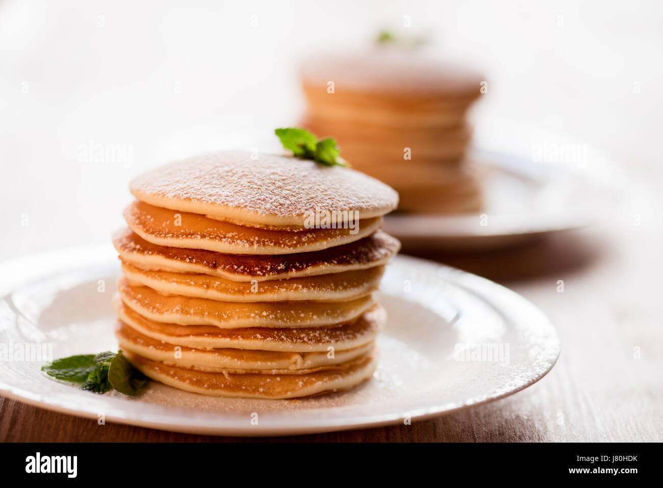 Délicieuses crêpes à la menthe et du sucre en poudre sur les plaques blanches Banque D'Images