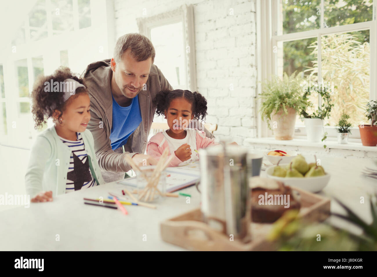 Père multi-ethnique et filles coloriage de cuisine Banque D'Images