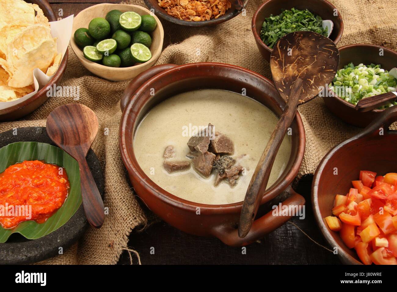 Soto Betawi populaires, la viande dans le lait de coco soupe de Jakarta. Servi avec tomate, céleri, oignon vert, échalotes, pirate, et de la chaux. Banque D'Images
