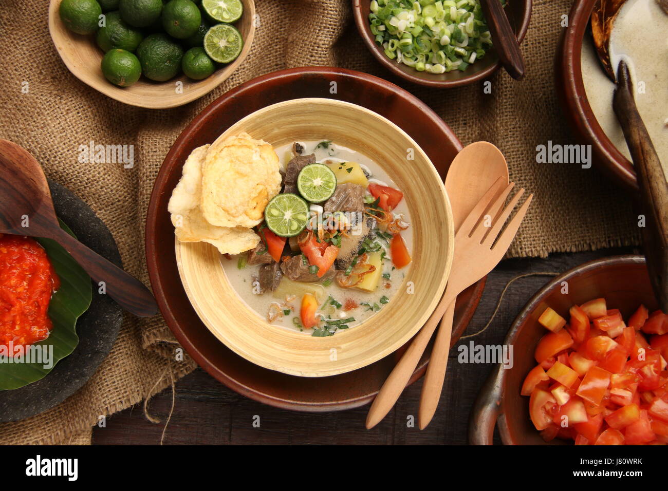 Soto Betawi populaires, la viande dans le lait de coco soupe de Jakarta. Servi avec tomate, céleri, oignon vert, échalotes, pirate, et de la chaux. Banque D'Images