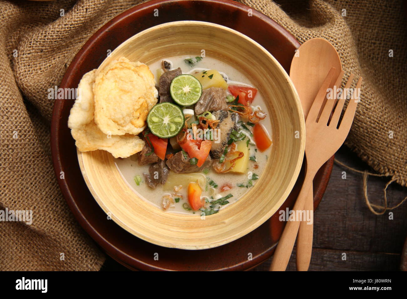 Soto Betawi populaires, la viande dans le lait de coco soupe de Jakarta. Servi avec tomate, céleri, oignon vert, échalotes, pirate, et de la chaux. Banque D'Images