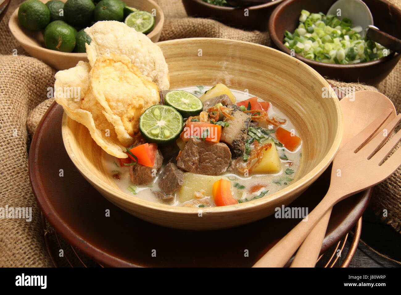 Soto Betawi populaires, la viande dans le lait de coco soupe de Jakarta. Servi avec tomate, céleri, oignon vert, échalotes, pirate, et de la chaux. Banque D'Images
