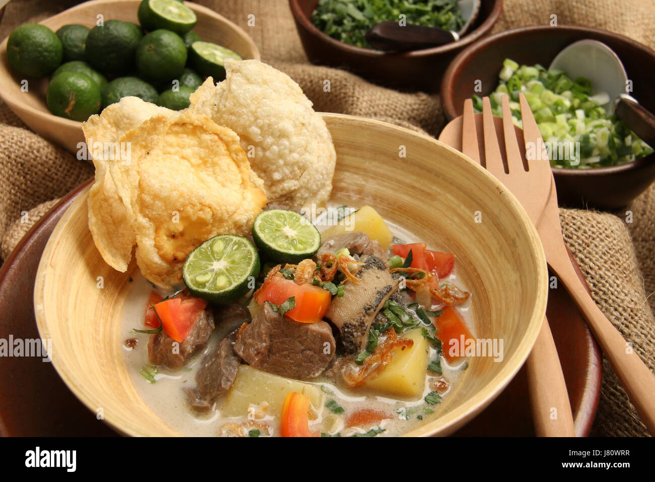 Soto Betawi populaires, la viande dans le lait de coco soupe de Jakarta. Servi avec tomate, céleri, oignon vert, échalotes, pirate, et de la chaux. Banque D'Images