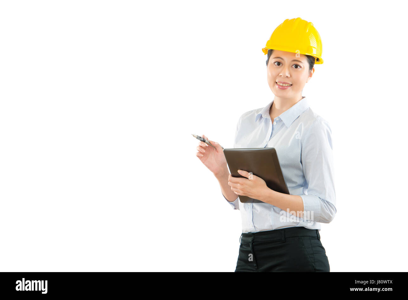 Chinois asiatique femme ingénieur entrepreneur avec chapeau hand holding digital tablet computer and pen inspection de structure d'un site de construction à isola Banque D'Images