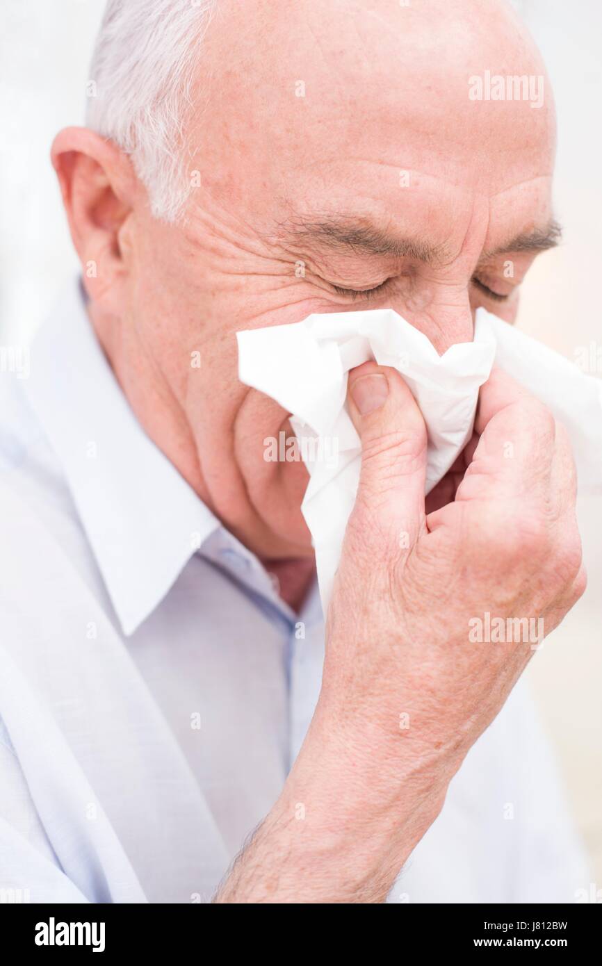 Man blowing nose sur les tissus. Banque D'Images