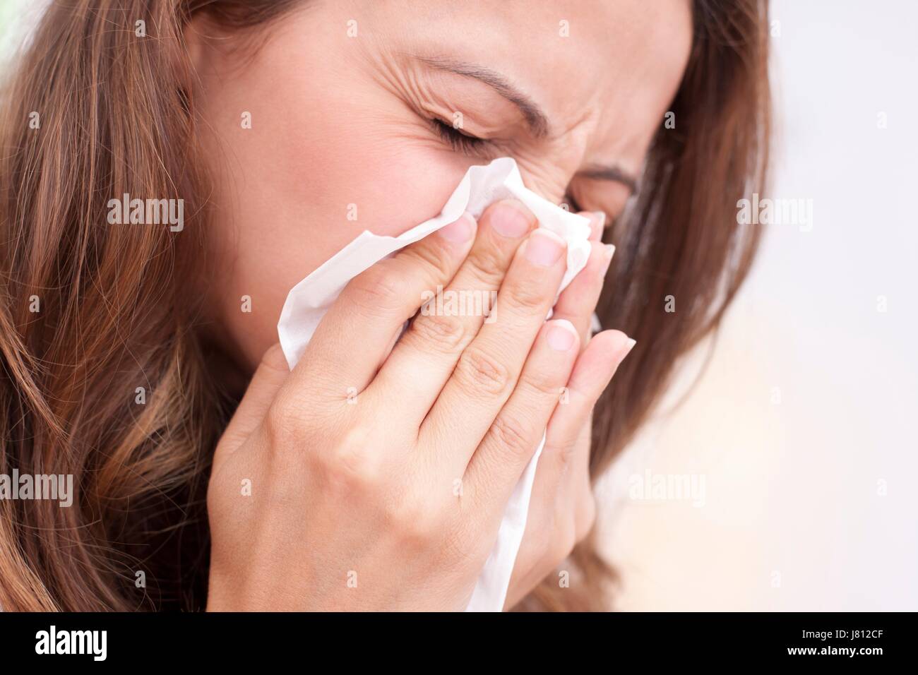 Woman blowing nose sur le tissu Banque D'Images
