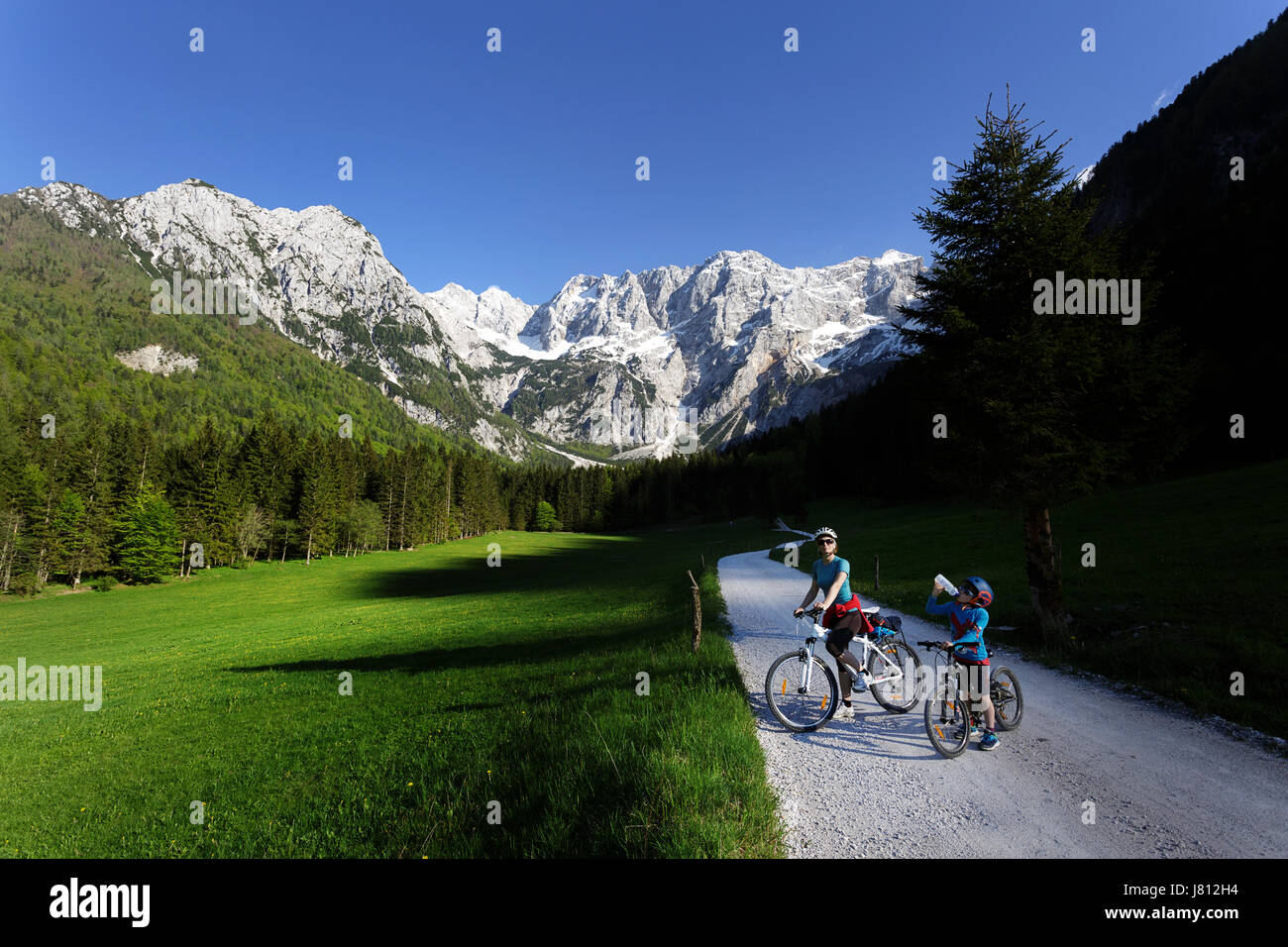 Mère et fils à vélo dans la vallée pittoresque de Jezersko, la Slovénie. Banque D'Images