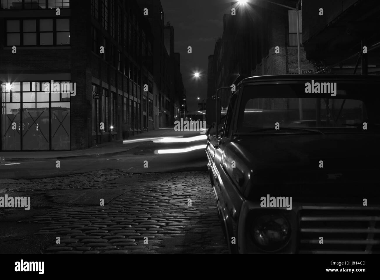 Nuit vanishing point vue vers le bas la rue Water à DUMBO, Brooklyn, longue exposition de fond avec look rétro. L'éclairage de rue de sodium et sur les sentiers de lumière fr Banque D'Images