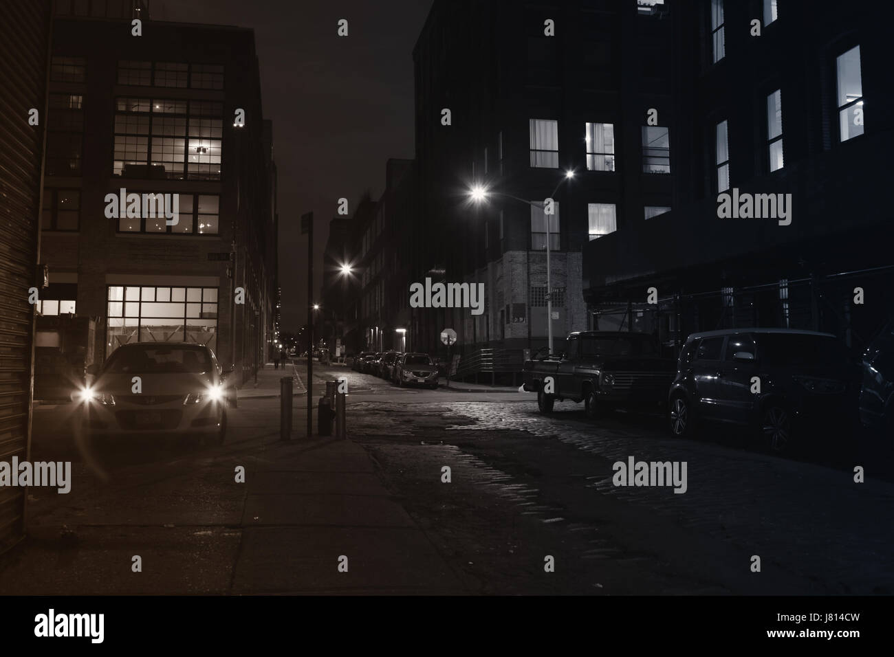Nuit vanishing point vue vers le bas la rue Water à DUMBO, Brooklyn, longue exposition de fond avec look rétro. L'éclairage de rue de sodium et sur les sentiers de lumière fr Banque D'Images