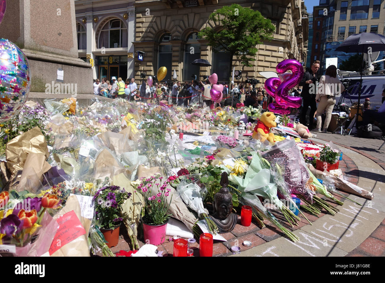 Une mer de ballons et tapis de fleurs St Anns carré comme pleureuses apporter hommages aux 22 victimes et la ville de Manchester a écrit sur le trottoir dans St Anns Square dans le centre-ville de Manchester en tant que personnes célèbrent et déposez un grief. Salman Abedi a fait exploser une bombe et est beleived pour faire partie d'une cellule terroriste à partir de la Libye. Banque D'Images
