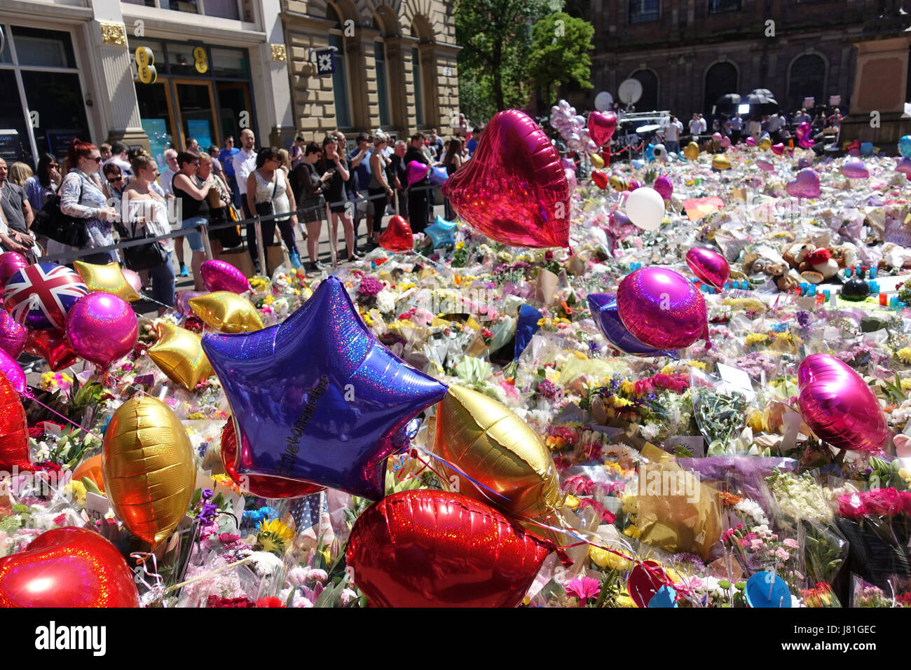 Une mer de ballons et tapis de fleurs St Anns carré comme pleureuses apporter hommages aux 22 victimes et la ville de Manchester a écrit sur le trottoir dans St Anns Square dans le centre-ville de Manchester en tant que personnes célèbrent et déposez un grief. Salman Abedi a fait exploser une bombe et est beleived pour faire partie d'une cellule terroriste à partir de la Libye. Banque D'Images