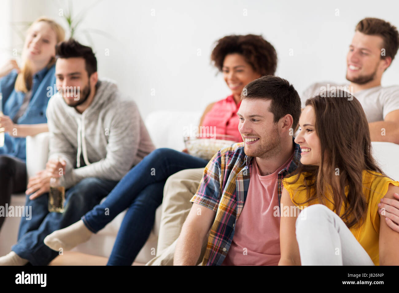 Happy friends watching tv à la maison Banque D'Images