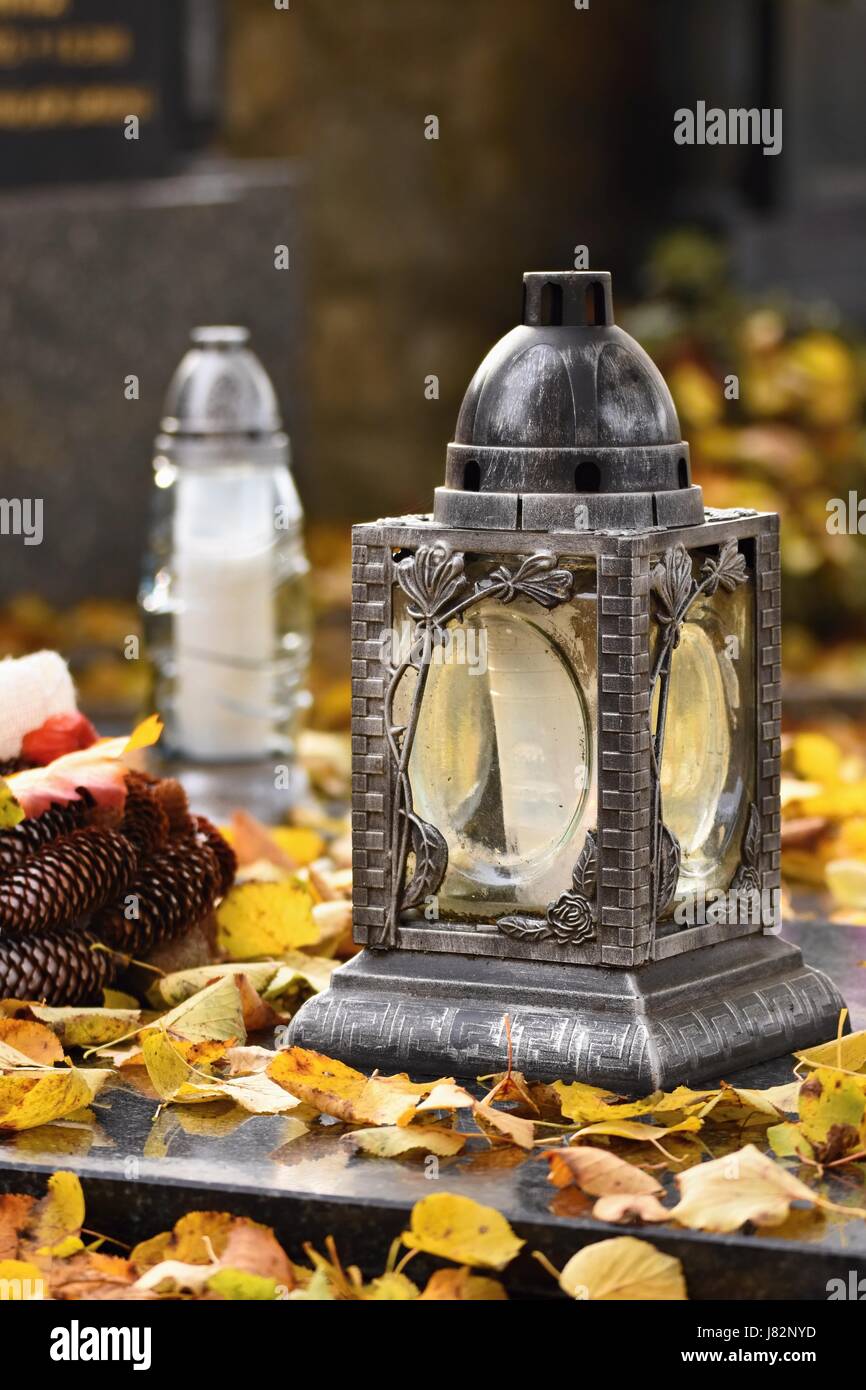 Beau concept d'automne au cimetière et l'Halloween. Bougie dans une lanterne sur la tombe. Arrière-plan de l'Halloween. Banque D'Images