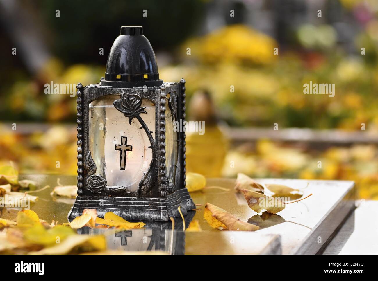 Beau concept d'automne au cimetière et l'Halloween. Bougie dans une lanterne sur la tombe. Arrière-plan de l'Halloween. Banque D'Images