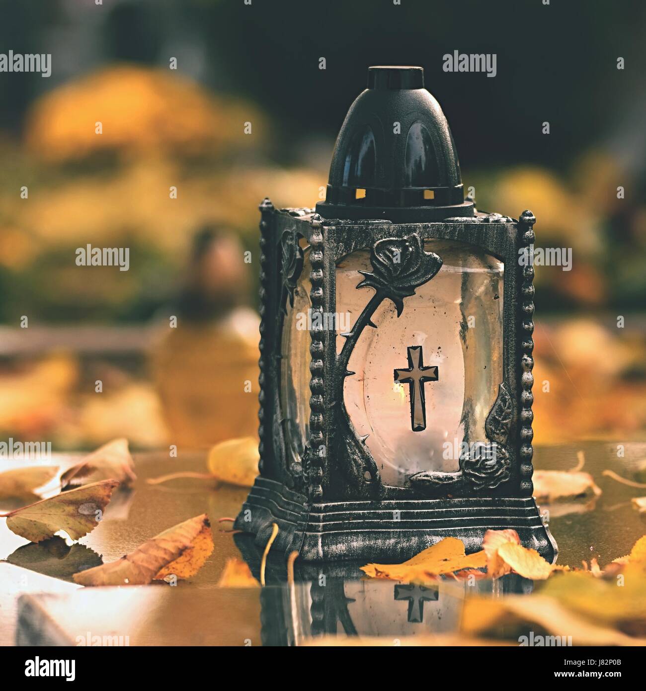Beau concept d'automne au cimetière et l'Halloween. Bougie dans une lanterne sur la tombe. Arrière-plan de l'Halloween. Banque D'Images