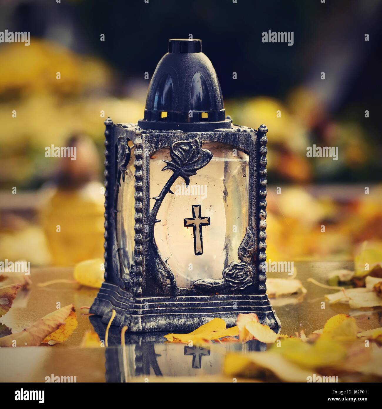Beau concept d'automne au cimetière et l'Halloween. Bougie dans une lanterne sur la tombe. Arrière-plan de l'Halloween. Banque D'Images