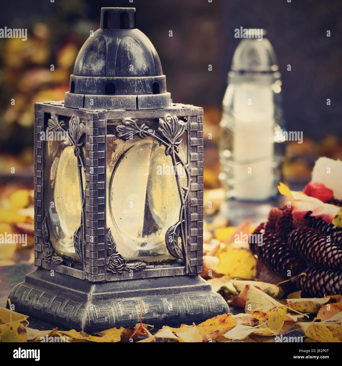 Beau concept d'automne au cimetière et l'Halloween. Bougie dans une lanterne sur la tombe. Arrière-plan de l'Halloween. Banque D'Images