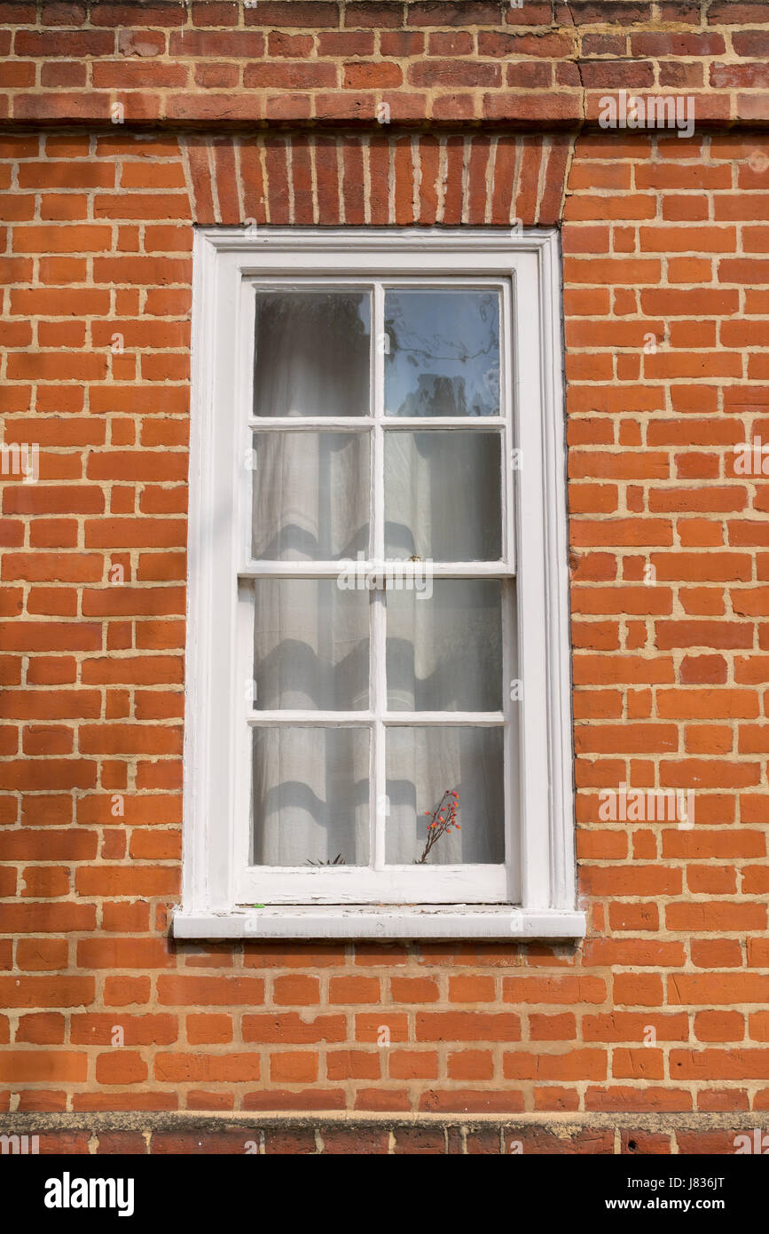 Fenêtre en bois vintage blanc sur un mur de brique rouge Banque D'Images