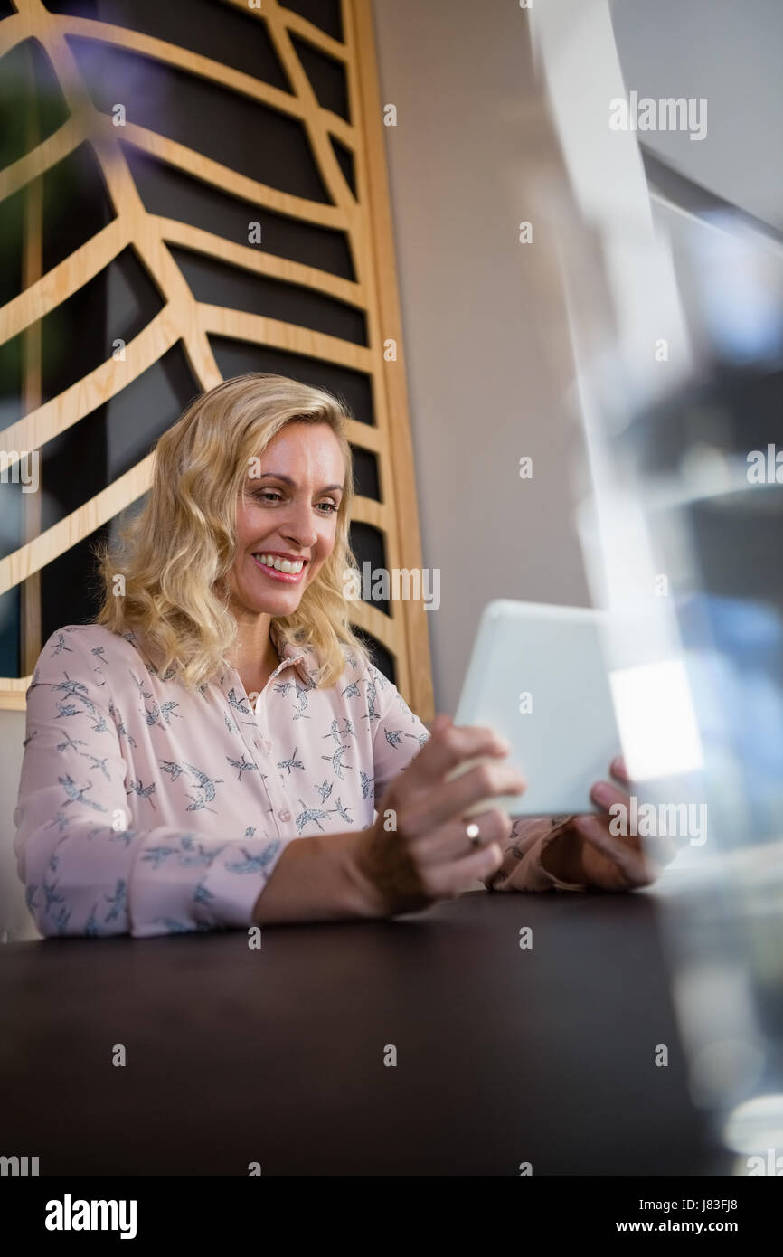 Happy businesswoman using digital tablet in cafe Banque D'Images