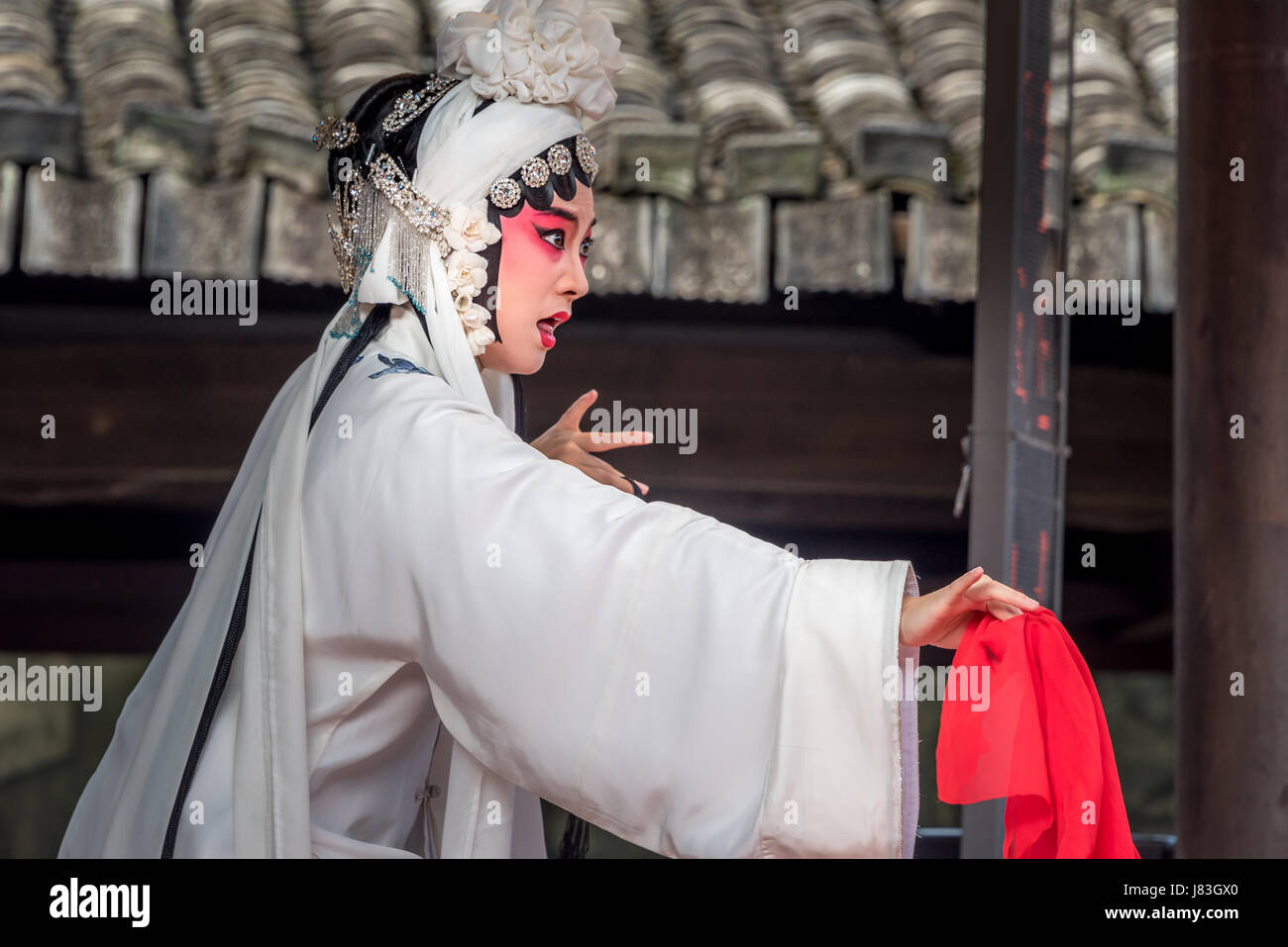 Moment dramatique de l'Opéra de Pékin chinois Kunqu Opera / interprète vêtu de blanc avec foulard rouge à Cangpo village, Yongjia County, province de Zhejiang. Banque D'Images