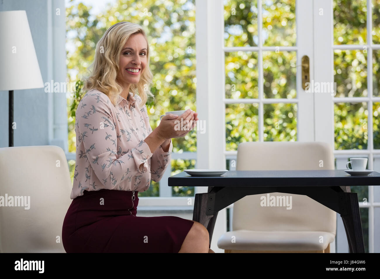 Portrait of smiling businesswoman holding Coffee cup in cafe Banque D'Images