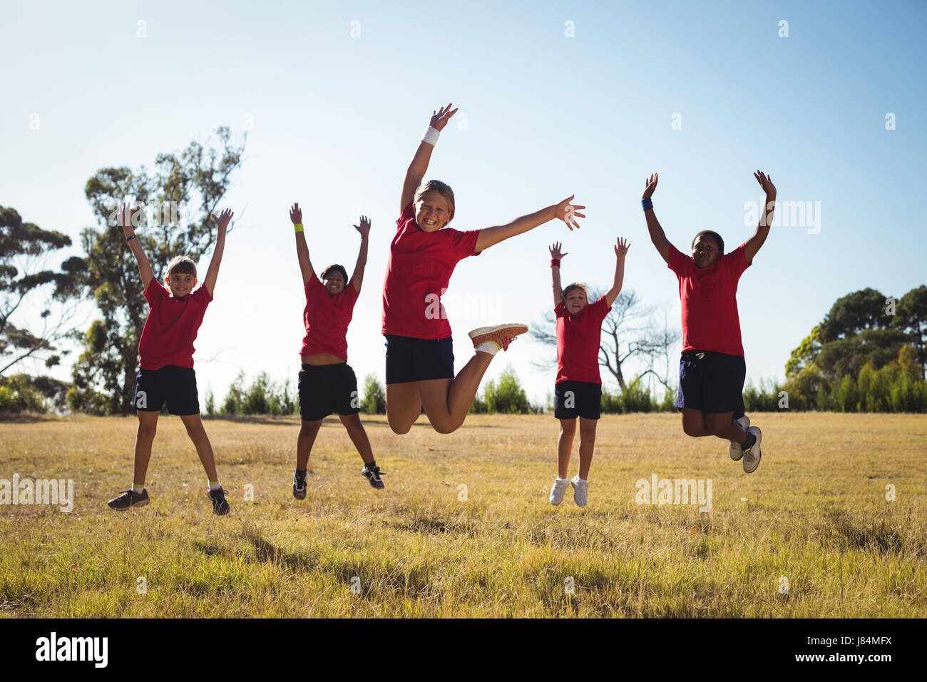 Groupe d'enfants s'amusant dans le boot camp sur une journée ensoleillée Banque D'Images