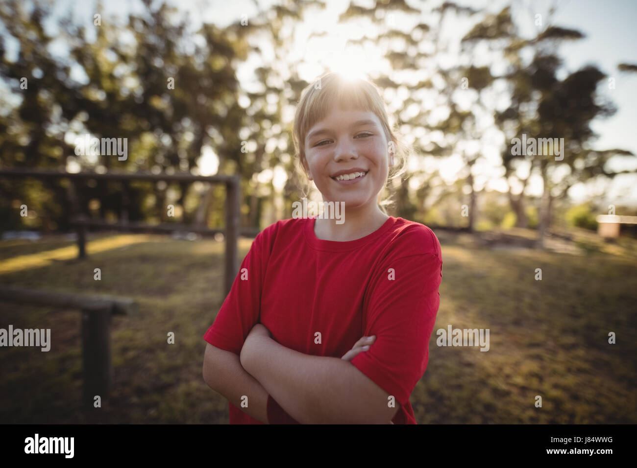 Portrait of happy Girl standing arms crossed dans boot camp Banque D'Images