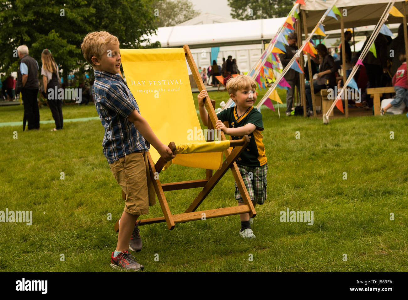 Hay-on-Wye, au Pays de Galles UK, samedi 27 mai 2017 Hay Festival 2017 - Deux jeunes garçons se précipiter pour obtenir leur transat, dans avant que la pluie arrive sur le troisième jour de la 30e Hay Festival crédit photo Credit : Keith morris/Alamy Live News Banque D'Images