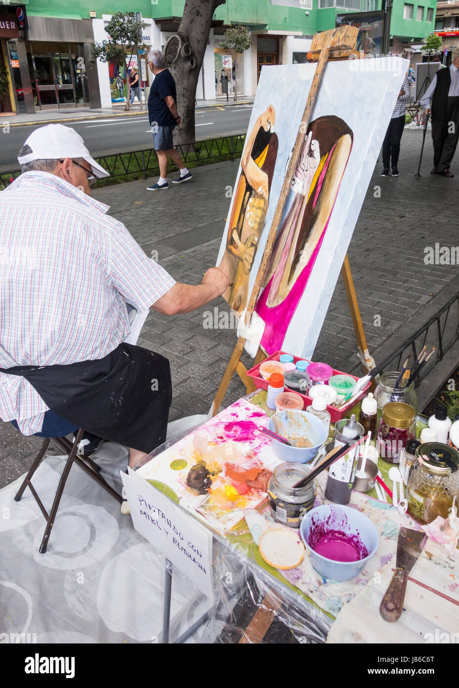Las Palmas, Gran Canaria, Îles Canaries, Espagne, le 27 mai 2017. Plus d'une centaine d'artistes en concurrence pour une part de l'Euro 11,000 prix en argent lors de l'Assemblée speed painting (5 heures ) la concurrence dans la rue à Las Palmas, la capitale de Gran Canaria. Sur la photo. Un artiste à l'aide de miel et de jus de betteraves rouges ( miel et remolacha )pour mélanger sa peinture en poudre. Credit : ALAN DAWSON/Alamy Live News Banque D'Images