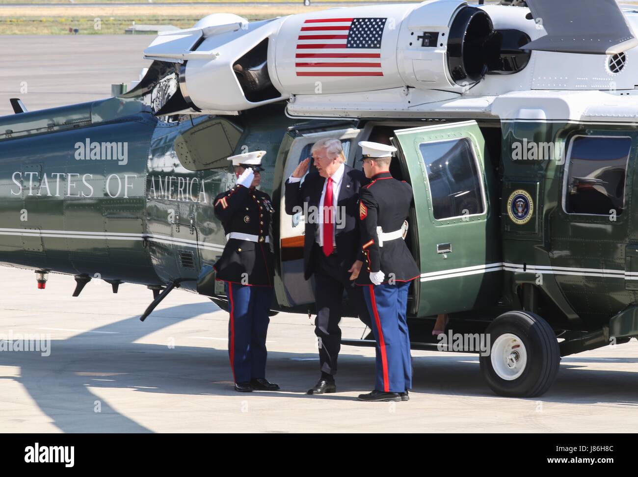 Le Président américain Donald Trump salue comme il arrive par hélicoptère vers des adresses des membres du service à la base aéronavale de Sigonella, avant de retourner à la maison de ses neuf jours de voyage outre-mer 27 Mai 2017 à Sigonella, en Italie. Banque D'Images
