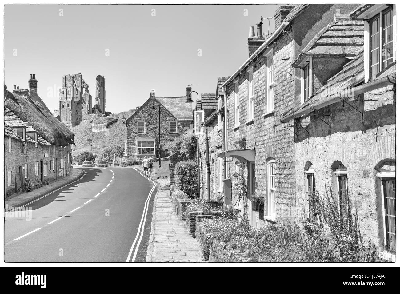 Route à travers le château de Corfe village avec vue sur le château de Corfe Castle, Dorset UK en Mai - noir et blanc monochrome N&B Banque D'Images