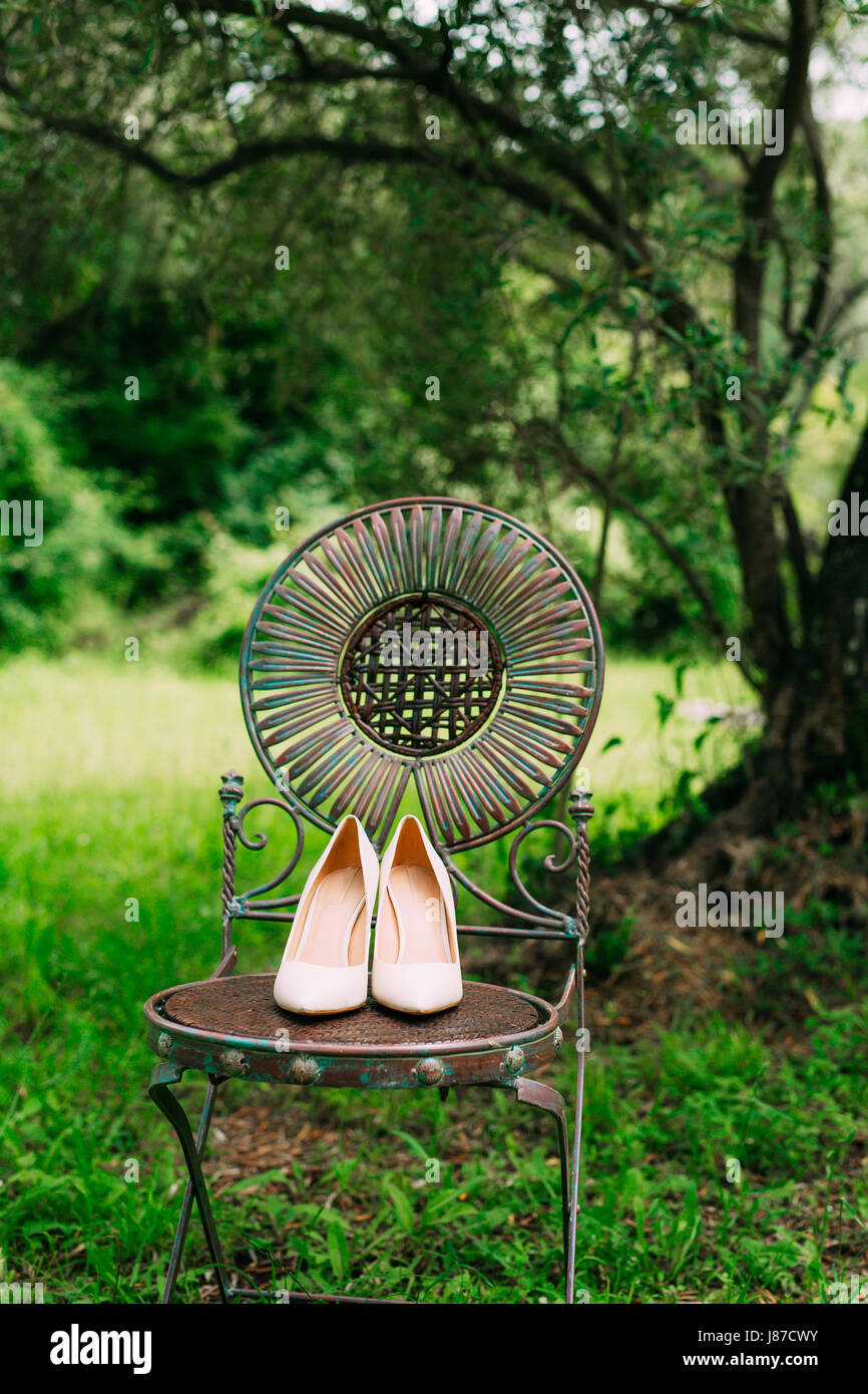 Chaussures de la mariée sur une chaise en métal vintage Banque D'Images