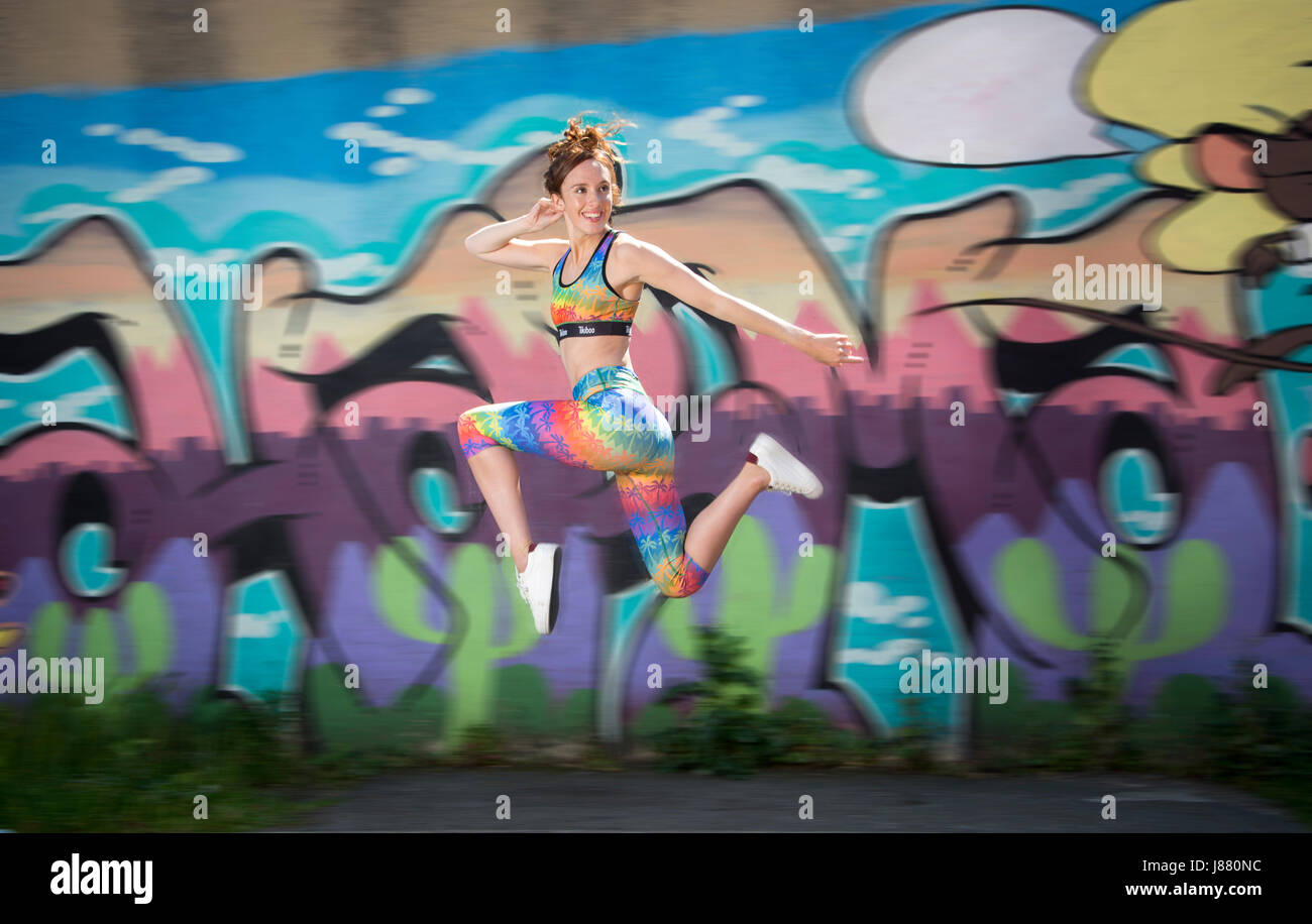 Femme courir et sauter, rester en forme, portant des vêtements colorés Banque D'Images