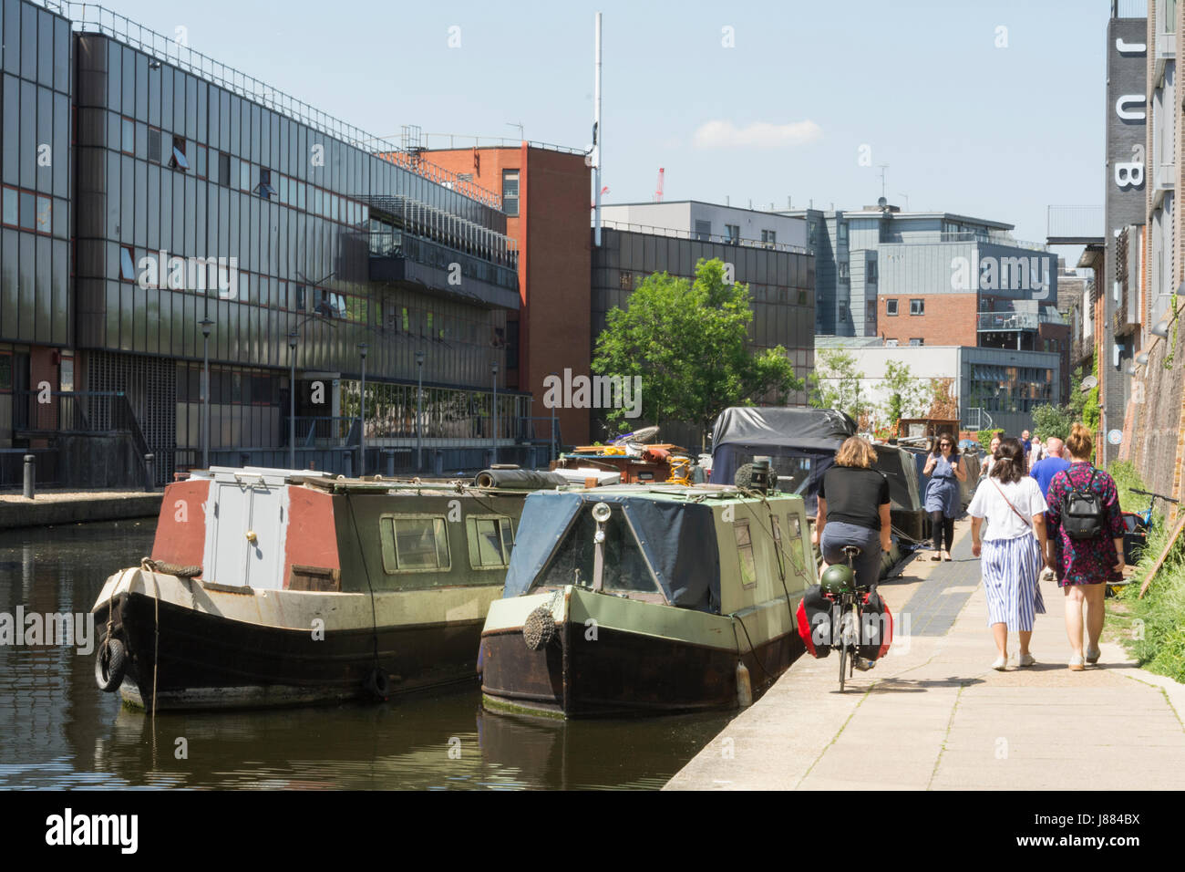 Les gens qui marchent le long du chemin de halage du canal et bateaux sur le Grand Union Canal près de King's Cross à Londres, Angleterre, Royaume-Uni. Banque D'Images