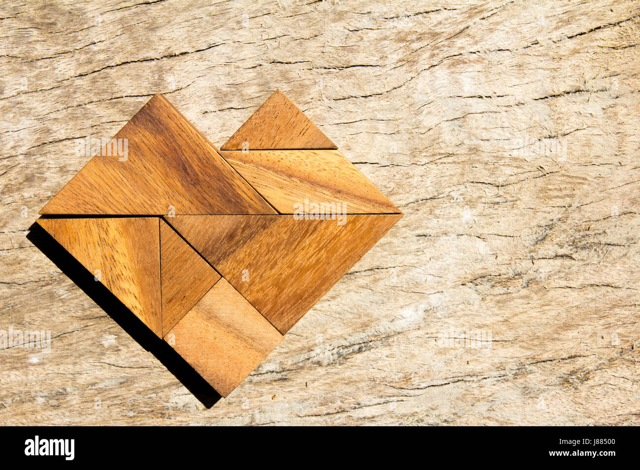 Casse-tête Tangram en forme de coeur sur fond de bois Banque D'Images