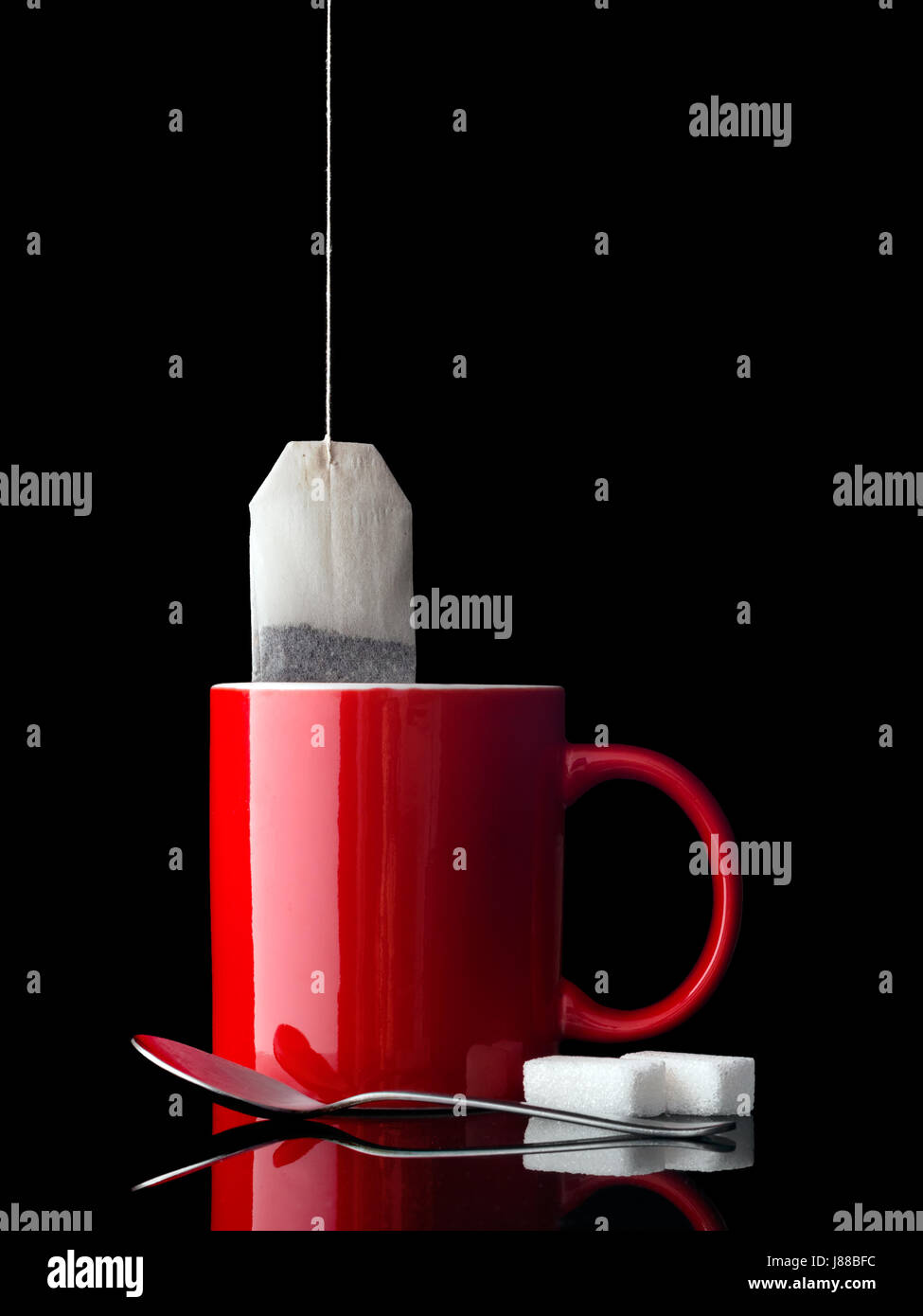 Tasse de thé. Avec cuillère et le sucre. Mug rouge, blanc. Infusion à base de plantes pourrait être également etc. Banque D'Images
