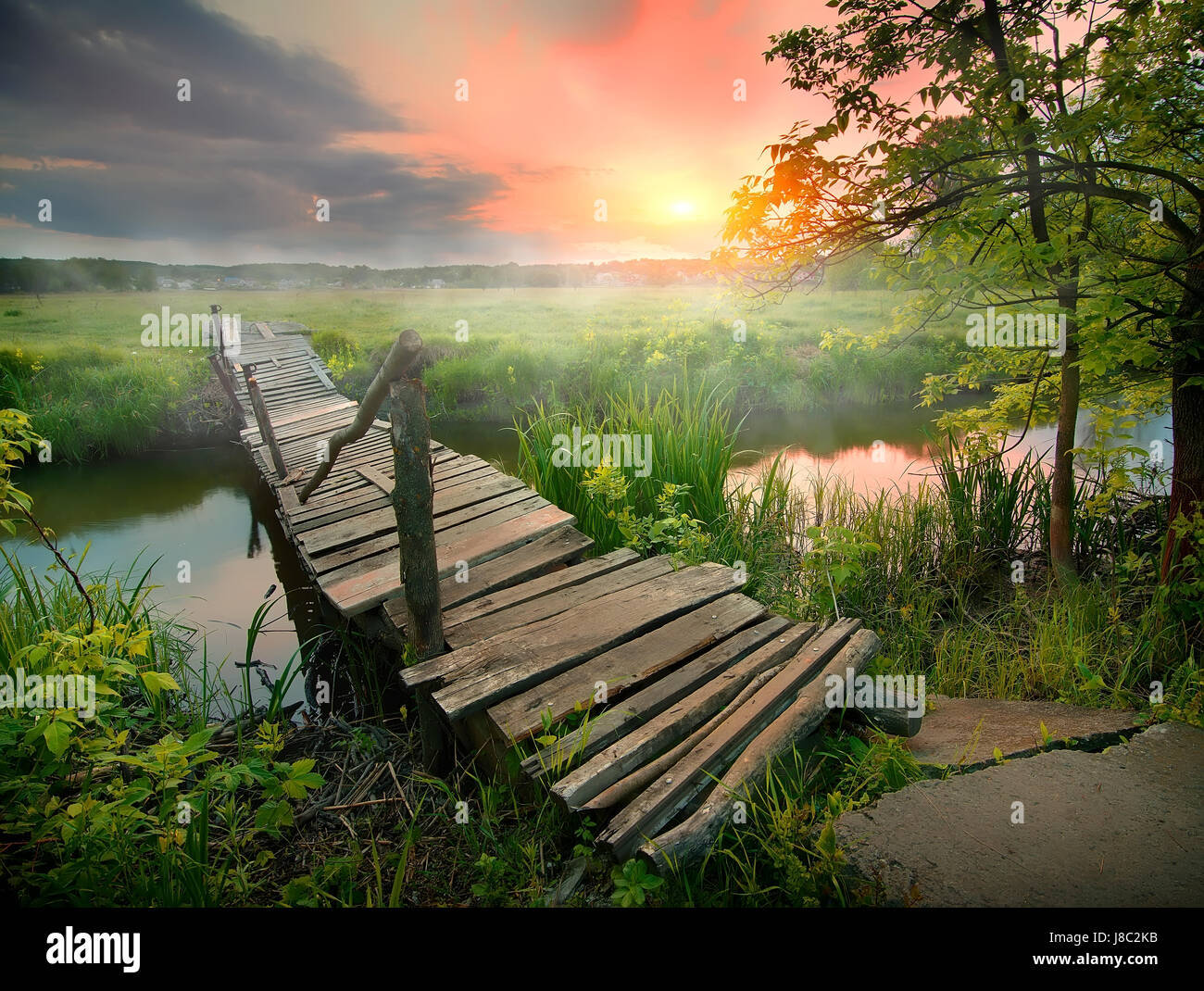 Vieux pont en bois à petite rivière au lever du soleil Banque D'Images