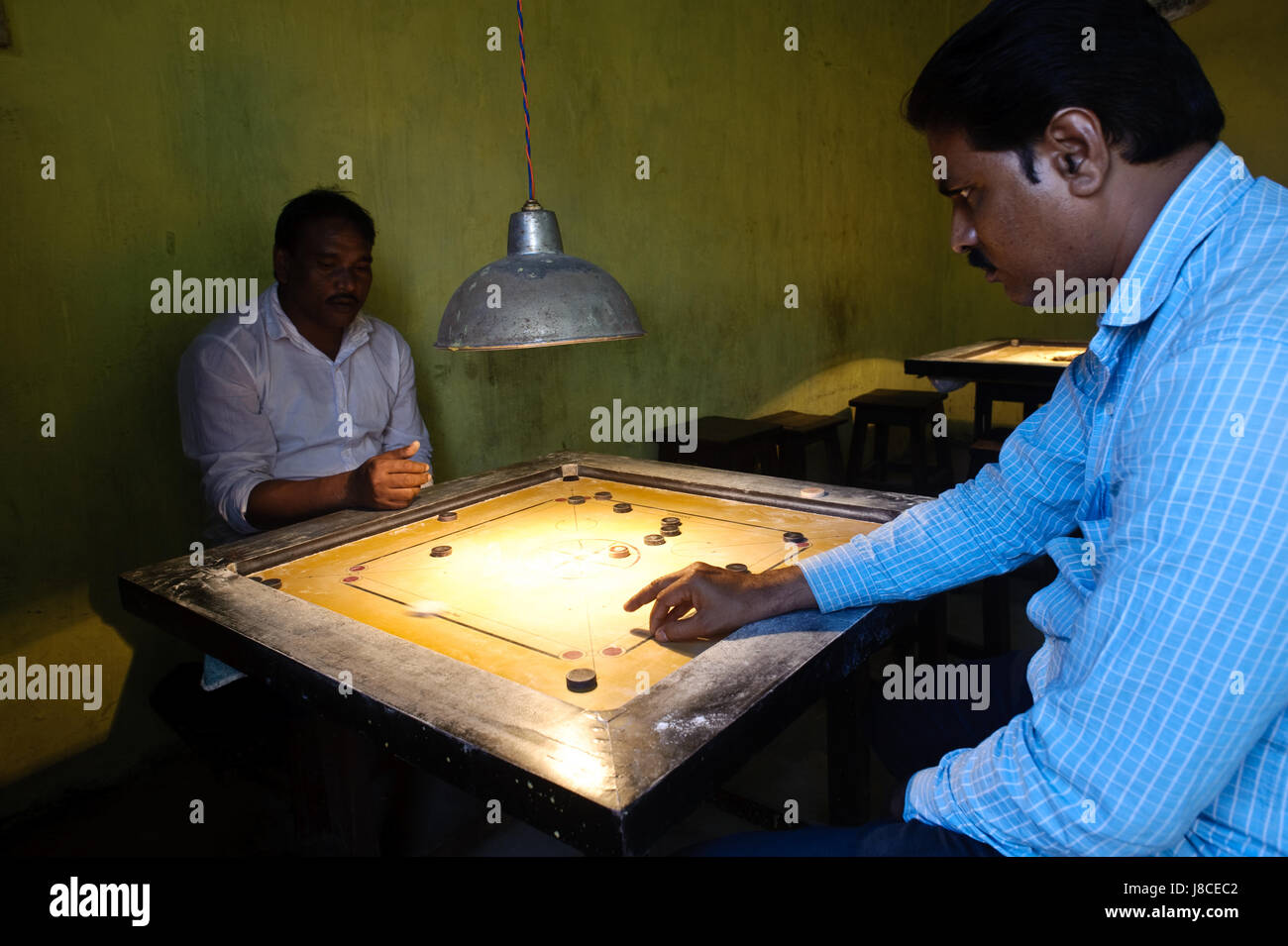 Deux hommes jouent aux carom dans une salle de jeux (Inde) Banque D'Images