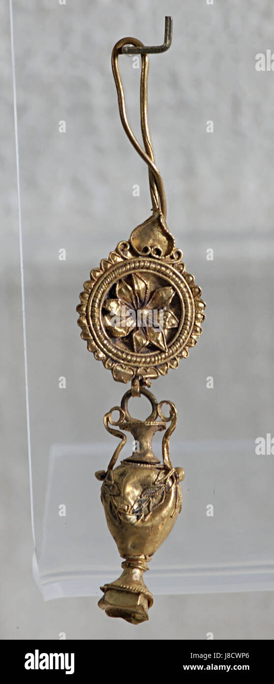 Cette image montre un bijou, une boucle d'oreille d'Athènes, représentant l'artisanat grec classique. La boucle d'oreille est probablement faite de matériaux précieux et présente un travail de conception complexe. Banque D'Images