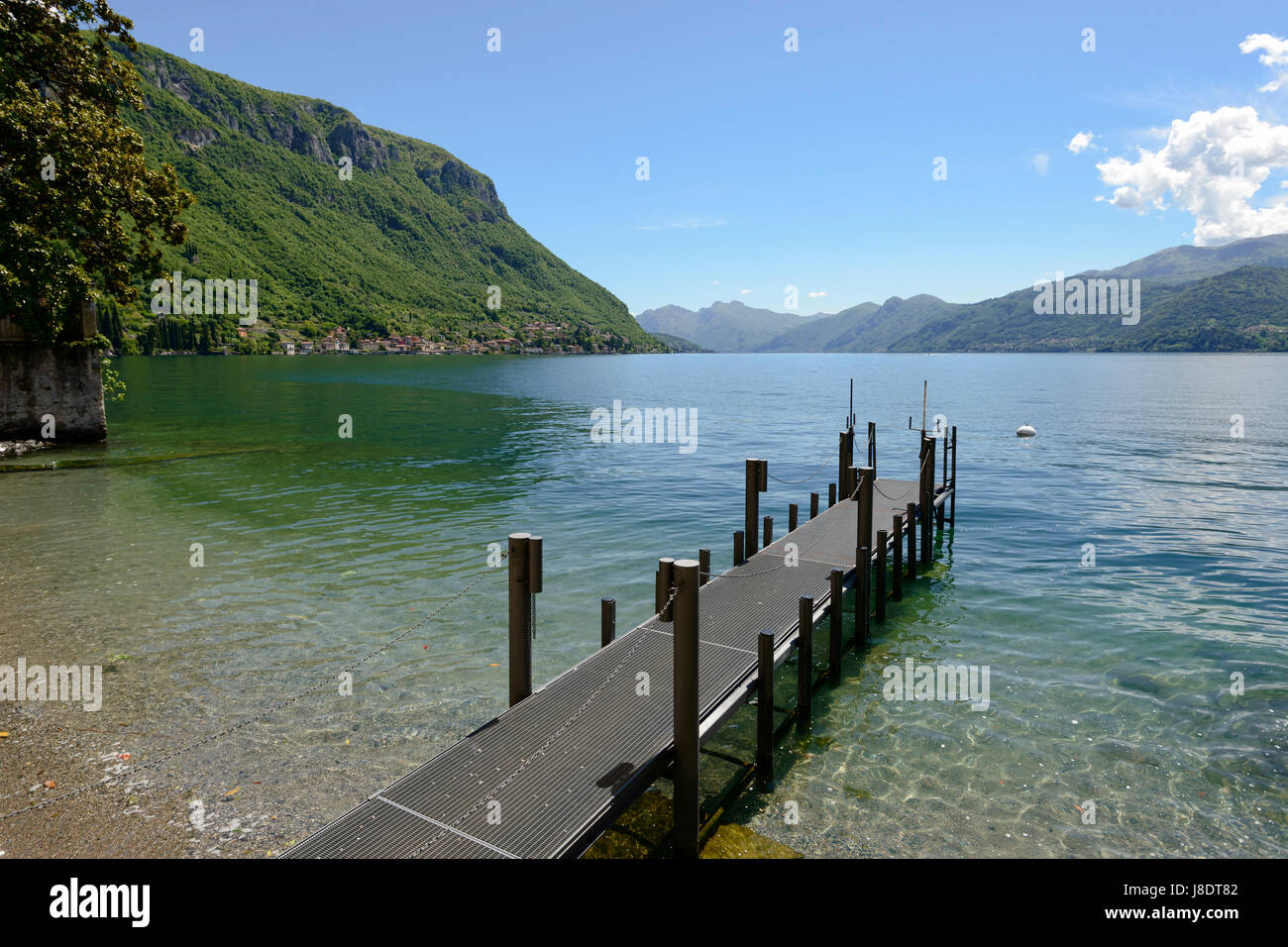 Une petite jetée sur une plage sur les rives du lac de Côme, tourné par un beau jour de printemps à Varenna , Italie Banque D'Images