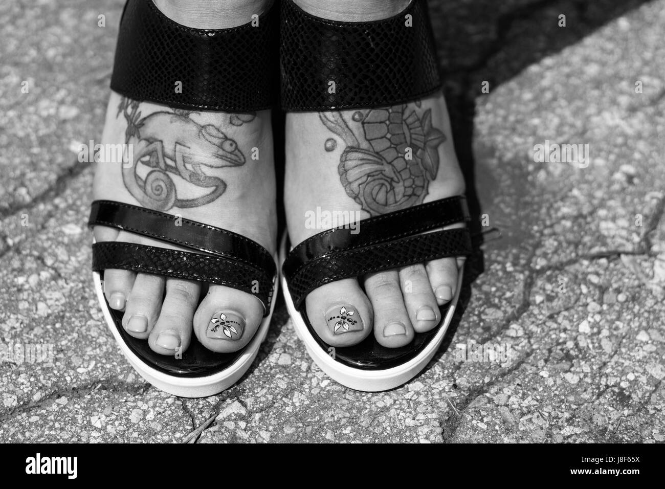 Pieds en sandales femme avec gros plan de tatouage Banque D'Images